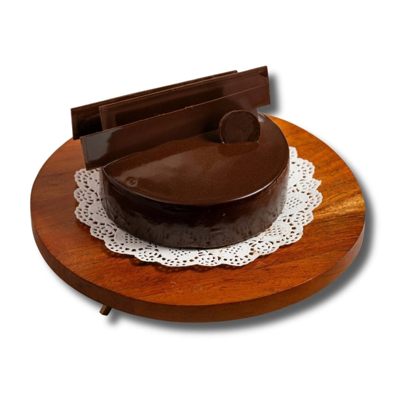 Wooden cake stand with a round wooden base and a brown cake on a white background